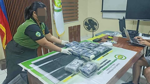 A Philippine Drug Enforcement Agency official shows the recovered packages containing suspected cocaine. The packages were found in a large dry bag floating in the water off Puerto Princesa City in the western Philippines on October 6, 2025.