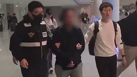 The extradited Filipino suspect being escorted by South Korean officials following his arrival at Incheon International Airport in Seoul, October 15, 2025
