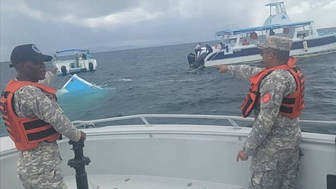 Personnel aboard a Dominican Republic Navy rescue boat observe the catamaran tour boat Boca de Yuma after it had become nearly completely submerged in Samana Bay, November 9, 2025.