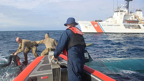 Personnel from the US Coast Guard medium endurance cutter USCGC Valiant offload narcotics from a semi-submersible vessel somewhere in the Eastern Pacific Ocean, September 1, 2019.