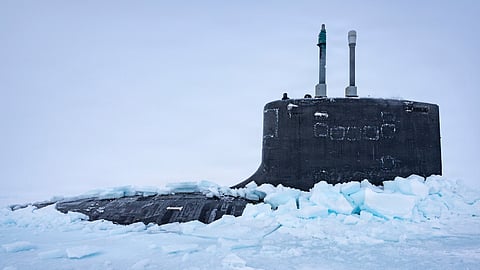 The US Navy Virginia-class fast-attack submarine USS Delaware emerges from the ice after performing a vertical surfacing to begin Operation Ice Camp 2026.