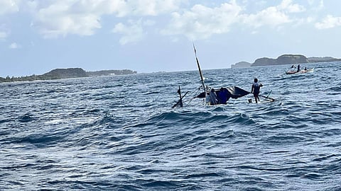 The partially submerged outrigger boat Triple R as seen from a Philippine Coast Guard response vessel off the coast of Cagayan province, May 16, 2026. All three crewmembers who were on the boat were later safely rescued.