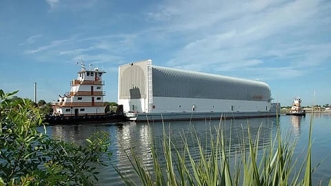 Tugs tow the Pegasus barge on the Banana River near the Kennedy Space Center in Florida