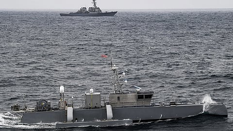 A Seahawk medium displacement unmanned surface vessel sails by the US Navy Arleigh Burke-class guided-missile destroyer USS Fitzgerald during US Pacific Fleet’s Unmanned Systems Integrated Battle Problem, April 21, 2021.