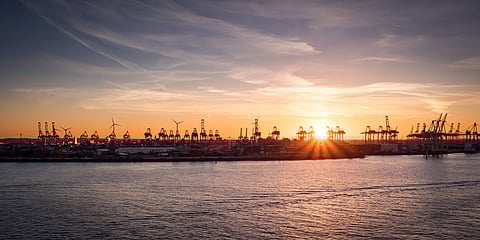 Photo of Hamburg  at sunrise with silhouette of cranes in port
