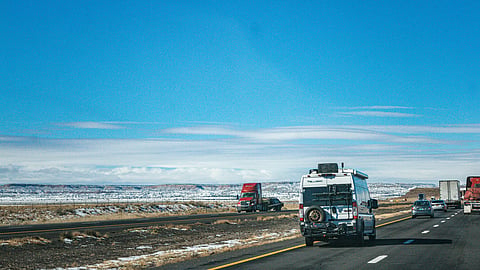 Photo of traffic on divided highway in desert after snow, New Mexico
