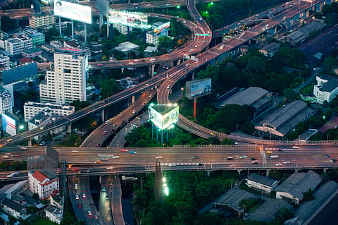 Photo of bustling Bangkok expressway intersection with city lights