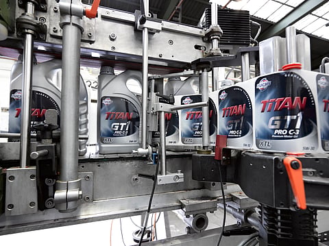Photo of FUCHS lubricants bottles on conveyer belt in blending plant