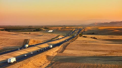 Photo of highway vehicles during sunset in California's desert terrain