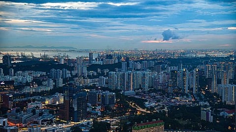 Photo of skyline of Singapore at dusk showcasing urban buildings, with port and vessels in background