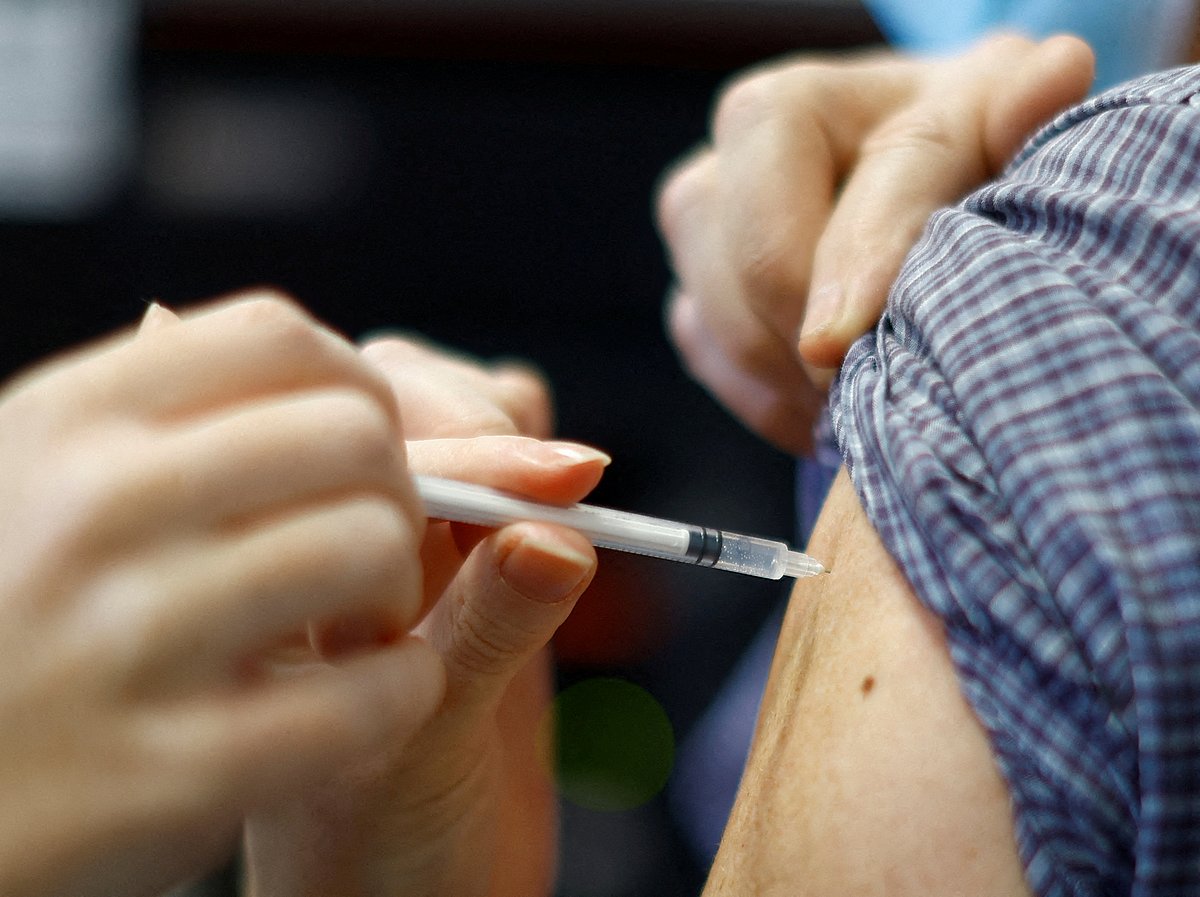 A medical worker administers a dose of the 