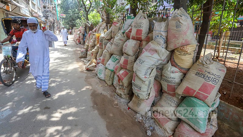 Construction materials have been kept on the road adjacent to the park of Dhaka North City Corporation between Block D and E of Mirpur 12. Photo: Asif Mahmud Ove