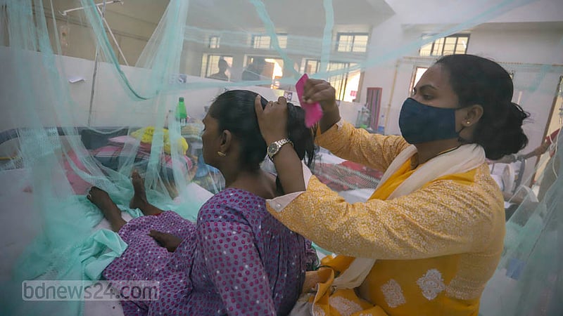 The daughter attends to Nemjan Begum, a dengue patient, at Shaheed Suhrawardy Medical College Hospital on Tuesday, Aug 30, 2022.
