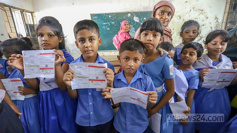 Children carry their COVID-19 vaccine cards before getting their first shots at Hazi Yousuf Ali Govt Primary School centre in Dhaka’s Kazipara.