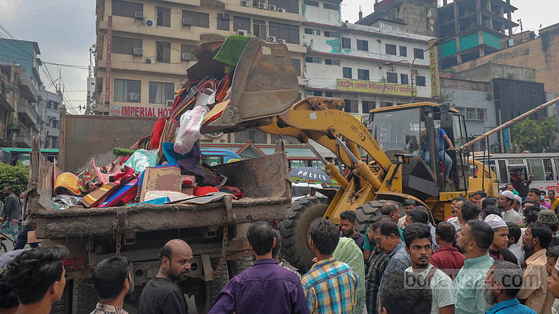 DSCC brings down many makeshift stores on footpaths with a bulldozer before transferring the debris to a truck in Gulistan on Sunday, Sept 11, 2022.