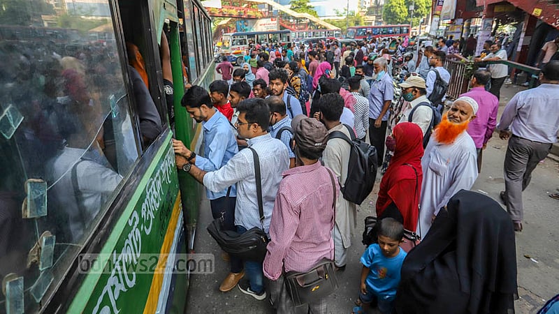 Commuters rush to board a bus after it stopped at a terminal in Dhaka’s Mirpur-10 on Monday, Oct 17, 2022.