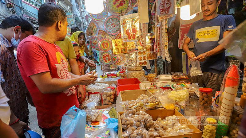 On the occasion of Lakshmi Puja, a Hindu devotee buys Prasad, or food offered to the deity, from a shop in Shankhari Bazar.
