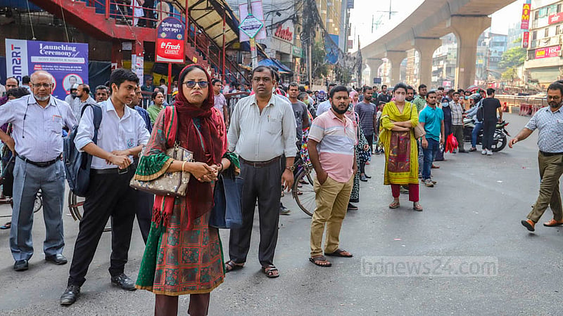 Commuters wait for a bus at Dhaka’s Mirpur-10 on Monday, Oct 17, 2022.