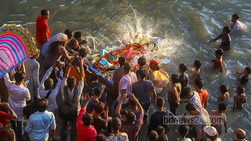 Hindu devotees immerse idols of goddess Durga in the Buriganga river at Basila in Mohammadpur on Bijoya Dashami on Wednesday, Oct 5, 2022.