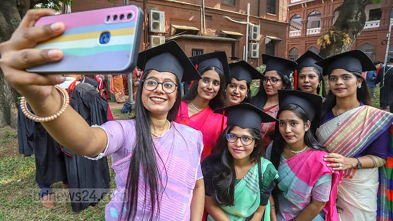 Dhaka University students wearing graduation gowns and caps take selfies at Curzon Hall on Friday, Nov 18, 2022, the eve of their 53rd convocation. Photo: Asif Mahmud Ove
