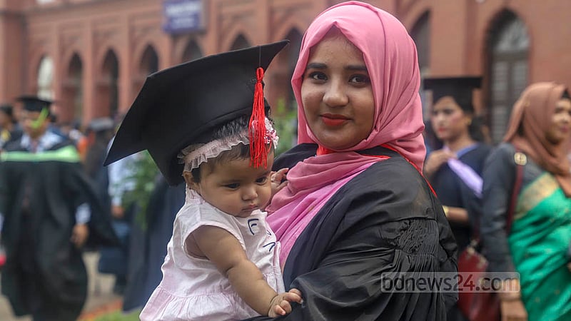 A Dhaka University student wearing a graduation gown poses for a photo with her baby daughter in her arms at Curzon Hall on Friday, Nov 18, 2022, ahead of the institution’s 53rd convocation. Photo: Asif Mahmud Ove