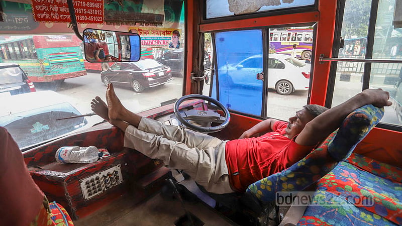 A bus driver tries to take a nap as workers from a garment factory of Olio Apparels Ltd block a road during protests over back pay in Dhaka’s Arambagh on Tuesday, Nov 1, 2022.Photo: Asif Mahmud Ove