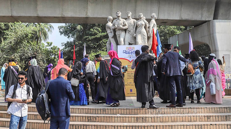 Dhaka University students wearing graduation gowns and caps take photos in front of the Raju Memorial Sculpture on Friday, Nov 18, 2022, ahead of their 53rd convocation. Photo: Asif Mahmud Ove