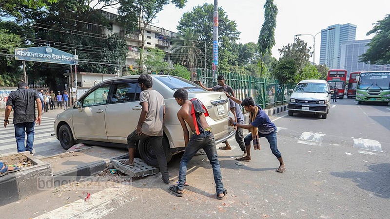 Vehicles stuck on the road turn through the pedestrian crossing as workers from a garment factory of Olio Apparels Ltd block a road during protests over back pay in Dhaka’s Arambagh on Tuesday, Nov 1, 2022. Photo: Asif Mahmud Ove