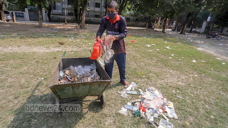A cleaner sweeps the plastic waste at Mohsin Hall playground littered by supporters and leaders of Jubo League attending an anniversary programme, Nov 12, 2022. Photo: Asif Mahmud Ove