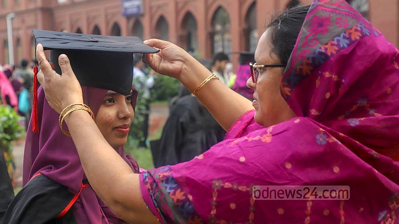 A woman puts a graduation cap on her daughter’s head at Dhaka University’s Curzon Hall on Friday, Nov 18, 2022, the eve of its 53rd convocation. Photo: Asif Mahmud Ove