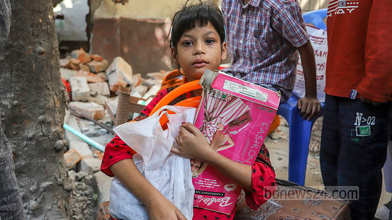 A girl sits with her toys outside the D-type colony in Dhaka’s Mohammadpur Housing Estate after the National Housing Authority evicted residents on Wednesday, Nov 23, 2022. Photo: Asif Mahmud Ove