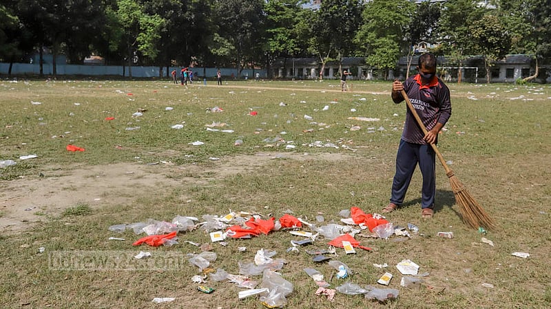 A cleaner sweeps the plastic waste at Mohsin Hall playground littered by supporters and leaders of Jubo League attending an anniversary programme, Nov 12, 2022. Photo: Asif Mahmud Ove