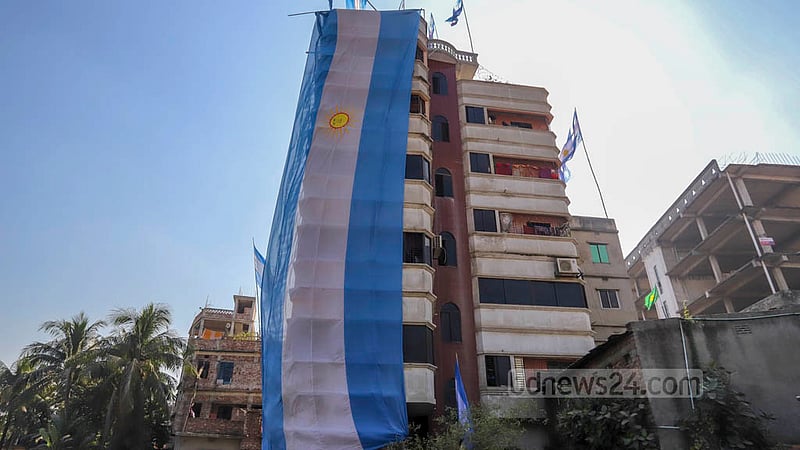 Football fans celebrate the start of the World Cup by hanging the flags of the teams they support in Amin Bazar on Sunday, Nov 20, 2022. Photo: Asif Mahmud Ove