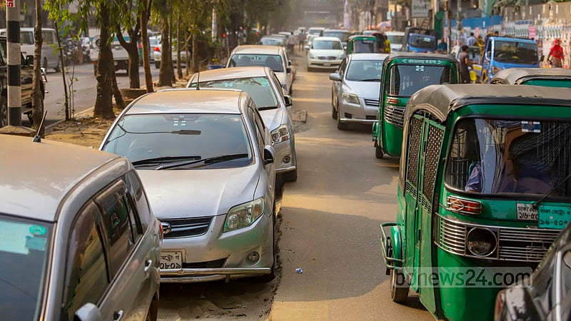 Parked cars on a stretch of unpaved road connecting Gulshan and Mohakhali in Dhaka are slowing down traffic on the busy thoroughfare.