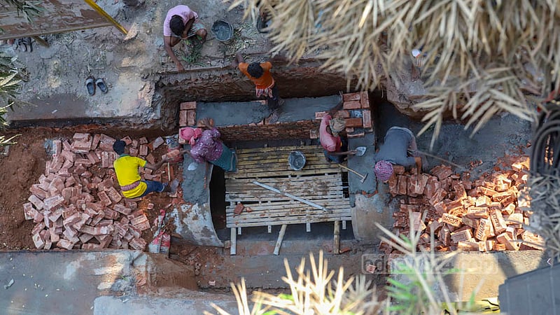 Workers set up sewerage lines on parts of Bir Uttom AK Khandaker Road in Dhaka’s Mohakhali. Photo: Asif Mahmud Ove