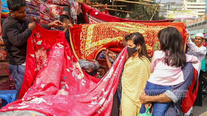 A family checks out blankets for sale at GPO Road beside Dhaka’s Baitul Mukarram Market on Monday, Dec 19, 2022. Photo: Mahmud Zaman Ovi