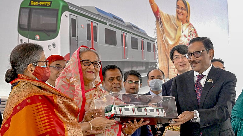 Road Transport and Bridges Minister Obaidul Quader hands a replica of a metro train to Prime Minister Sheikh Hasina and her sister Sheikh Rehana at the inauguration of Dhaka Metro Rail in Uttara’s Diabari on Wednesday, Dec 28, 2022. Photo: PMO