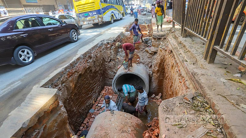 Workers set up sewerage lines on parts of Bir Uttom AK Khandaker Road in Dhaka’s Mohakhali. Photo: Asif Mahmud Ove