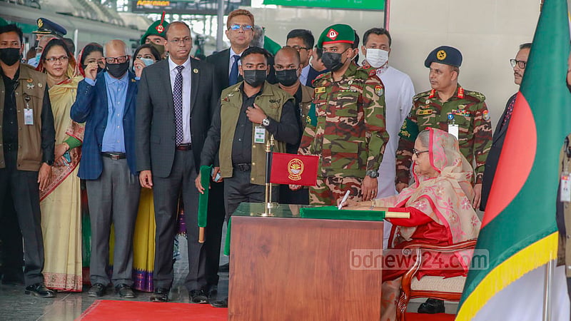 Prime Minister Sheikh Hasina signs a flag she waved to give the green signal to Bangladesh’s first metro train at Uttara North Station before boarding it on Wednesday, Dec 28, 2022. Photo: Mostafigur Rahman