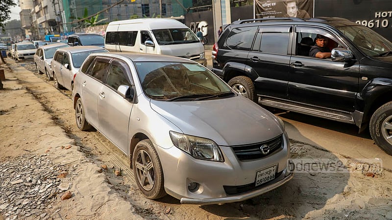 Parked cars on a stretch of unpaved road connecting Gulshan and Mohakhali in Dhaka are slowing down traffic on the busy thoroughfare.