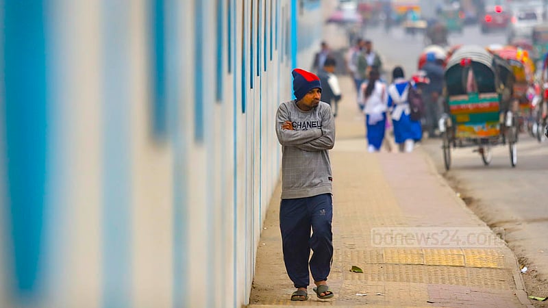 A man walks on a footpath in Dhaka on Jan 4, 2023, as a chilly wind sweeps Bangladesh for a few days with the sun out of view. Photo: Mahmud Zaman Ovi