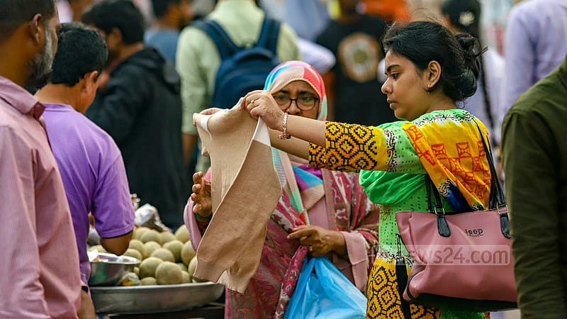 Women check winter clothes at a makeshift shop on the footpath outside New Market in Dhaka.