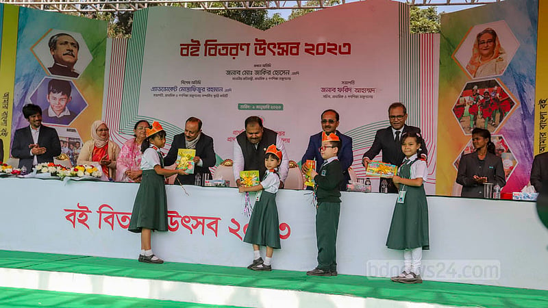 Guests hand new textbooks to primary students during the “Book Distribution Festival” at Dhaka University’s central playground on Sunday, Jan 1, 2023. Photo: Asif Mahmud Ove
