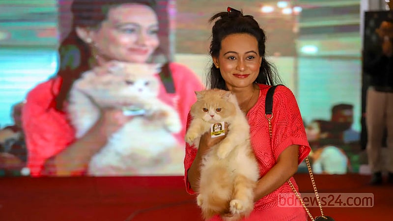 A woman brings her pet cat to the first Cat Ramp Show at Jamuna Future Park in Dhaka on Friday, Feb 24, 2023. Photo: Asif Mahmud Ove