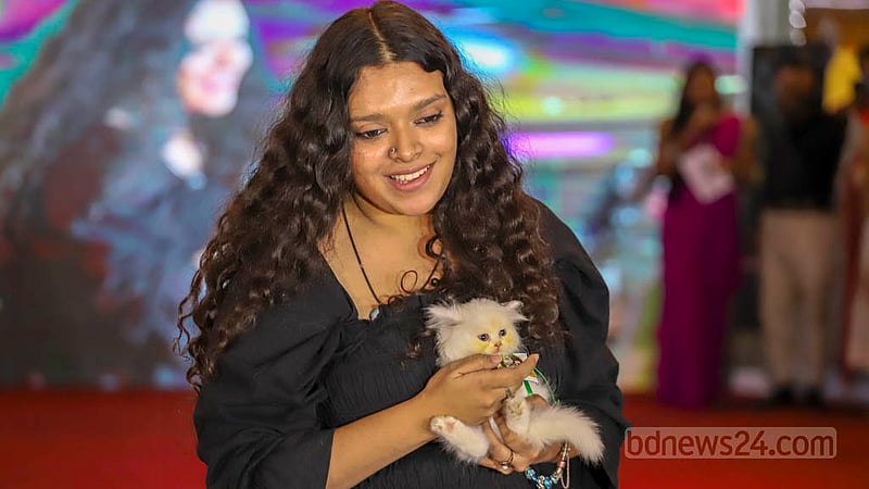 A woman brings her pet cat to the first Cat Ramp Show at Jamuna Future Park in Dhaka on Friday, Feb 24, 2023. Photo: Asif Mahmud Ove