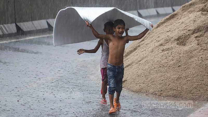 Children rush to take shelter from the rain in Dhaka on Sunday, May 19, 2023. Photo: Asif Mahmud Ove