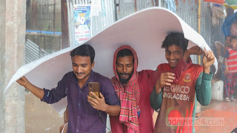 People rush to take shelter from the rain in Dhaka on Sunday, May 19, 2023. Photo: Asif Mahmud Ove
