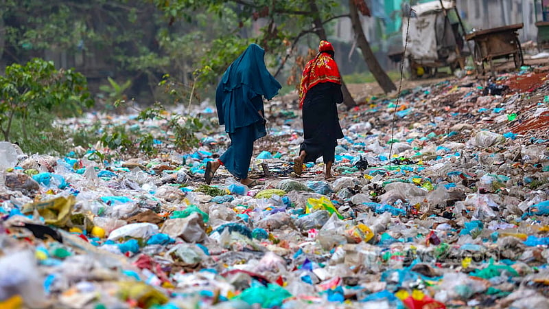 The layers of waste on the Shubhaddya canal in Dhaka's Keraniganj are so thick that two women can cross it by walking on the surface. Photo: Mahmud Zaman Ovi