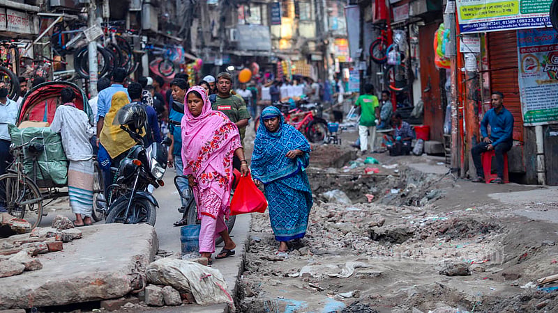 Commuters face a hard time travelling through Kazi Alauddin Road in Old Dhaka as sewerage repair work has blocked much of it. Photo: Mahmud Zaman Ovi