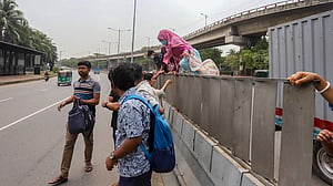 People scale traffic median to cross street